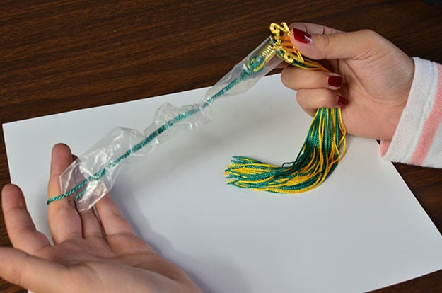 Expose year charm while keeping tassel sleeve on