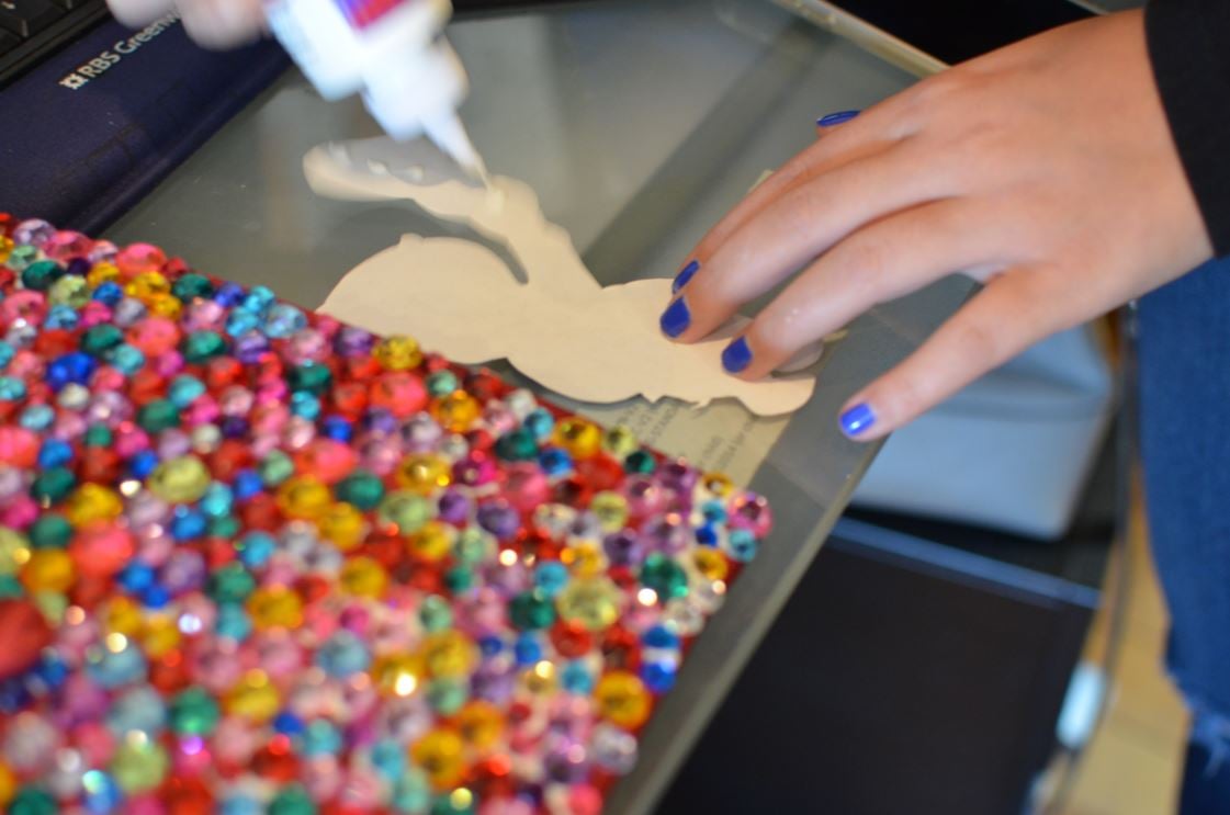 Applying glue dots to the back of a cutout